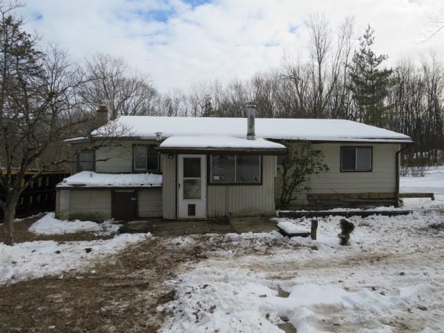 view of snow covered rear of property