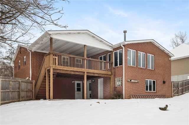 snow covered house with a deck