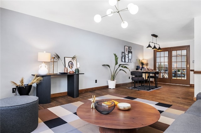 living room with an inviting chandelier and dark wood-type flooring