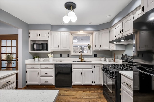 kitchen with dark hardwood / wood-style floors, pendant lighting, sink, white cabinets, and black appliances