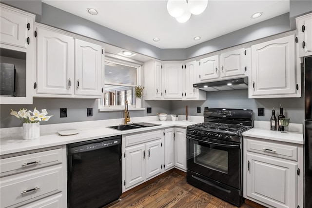 kitchen with dark hardwood / wood-style flooring, sink, black appliances, and white cabinets