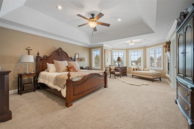 carpeted bedroom with ceiling fan, ornamental molding, and a raised ceiling