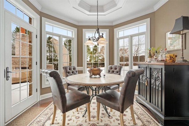 sunroom / solarium featuring a tray ceiling and a notable chandelier