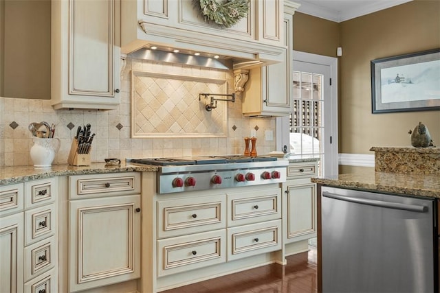 kitchen with light stone counters, appliances with stainless steel finishes, custom range hood, cream cabinets, and backsplash