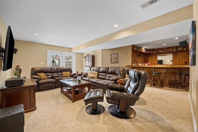 living room with french doors, light colored carpet, and indoor bar