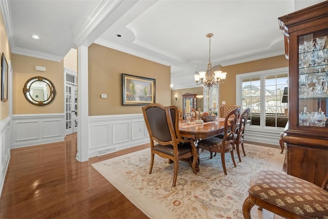 dining room featuring a notable chandelier, wood-type flooring, and ornamental molding