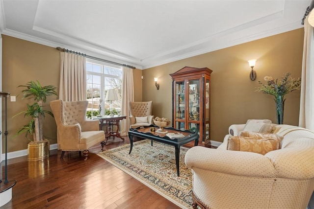 living area featuring dark hardwood / wood-style flooring, ornamental molding, and a raised ceiling