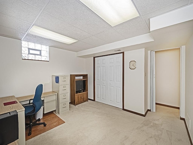 carpeted office space featuring a paneled ceiling