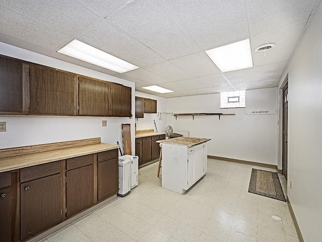 kitchen featuring dark brown cabinets and a paneled ceiling