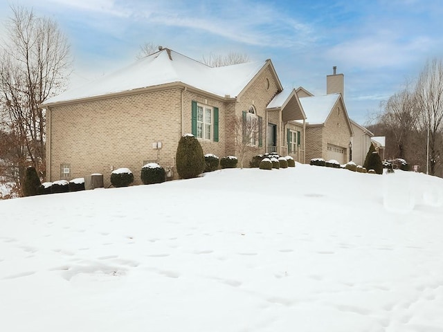 view of snow covered exterior featuring a garage