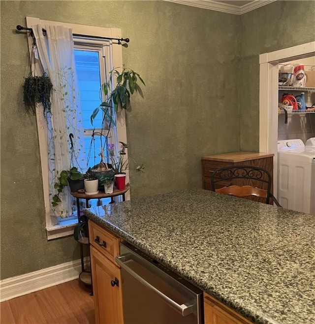 interior space featuring crown molding, hardwood / wood-style flooring, and washer and clothes dryer