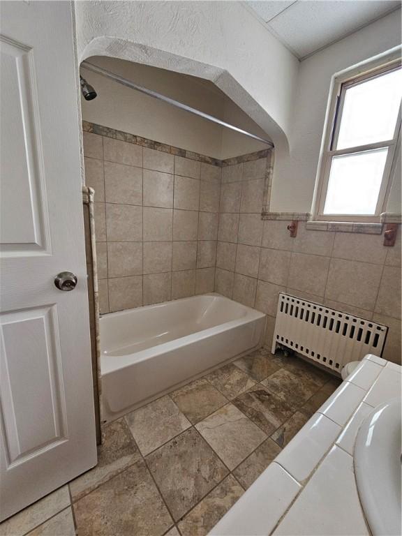 1732 Pennsylvania Ave, West Mifflin, PA 15122 - bathroom featuring radiator, bathing tub / shower combination, and tile walls