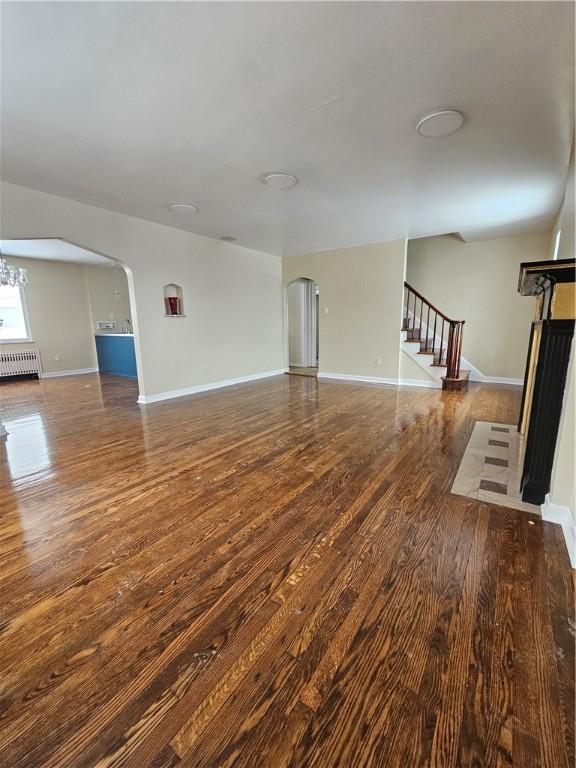 unfurnished living room featuring dark hardwood / wood-style flooring and radiator