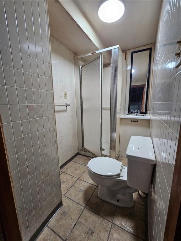1732 Pennsylvania Ave, West Mifflin, PA 15122 - full bathroom featuring tile walls, toilet, and a shower stall