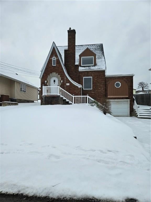 snow covered property with a garage