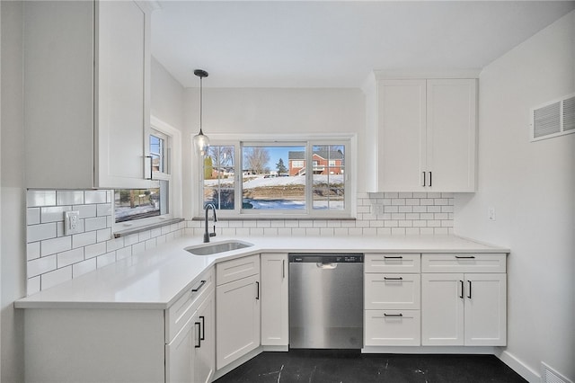 kitchen with pendant lighting, tasteful backsplash, white cabinetry, dishwasher, and sink