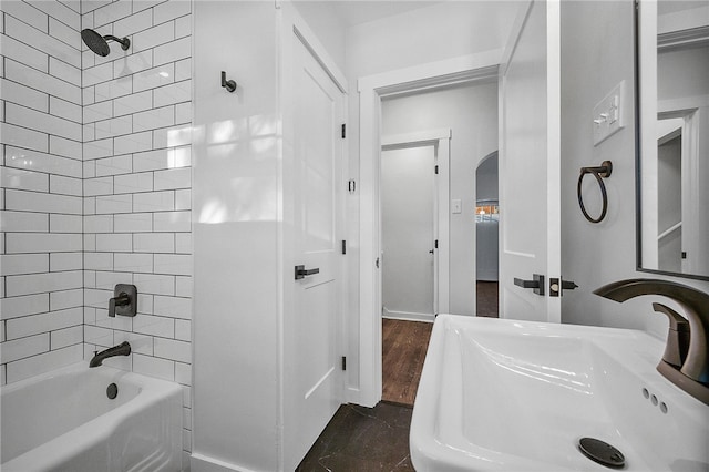 bathroom featuring tiled shower / bath combo and sink