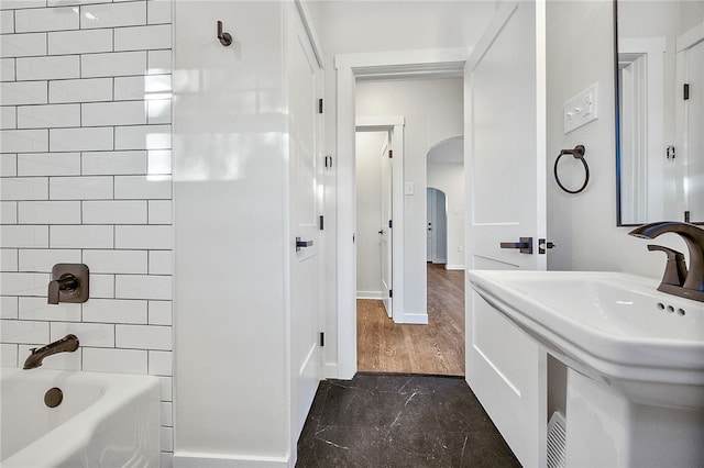 bathroom featuring tiled shower / bath combo and sink