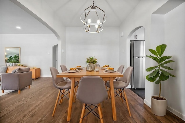 dining space with dark hardwood / wood-style flooring and a chandelier