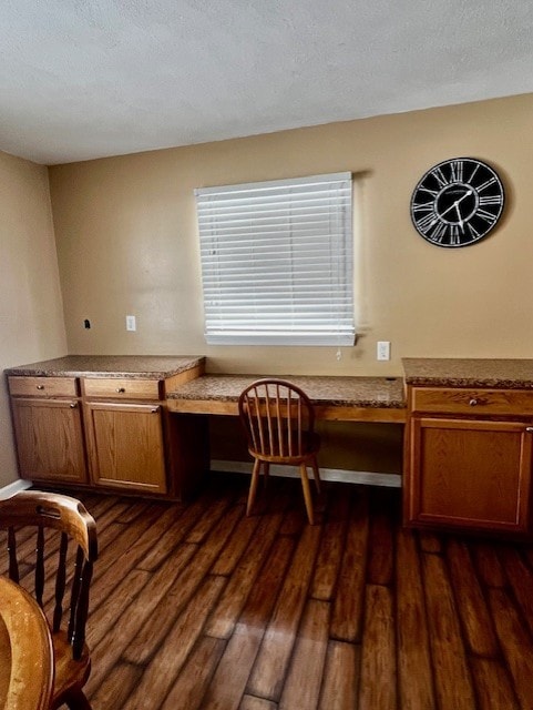 office area featuring dark wood-type flooring and built in desk