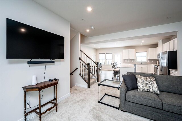 living room featuring sink and light carpet