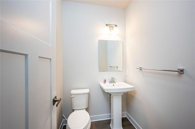 bathroom featuring wood-type flooring and toilet