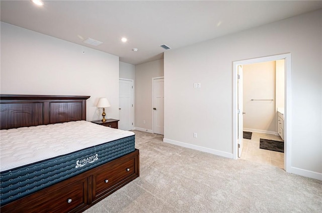 carpeted bedroom featuring ensuite bath