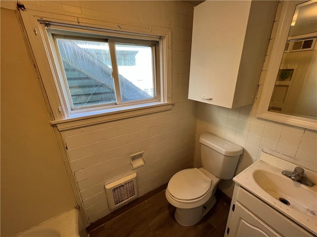 bathroom featuring vanity, hardwood / wood-style floors, tile walls, and toilet