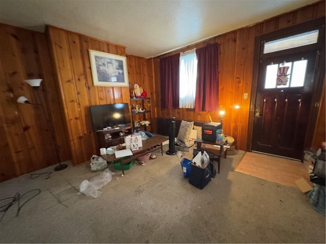 carpeted living room featuring wood walls