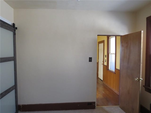 interior space featuring dark colored carpet and a barn door