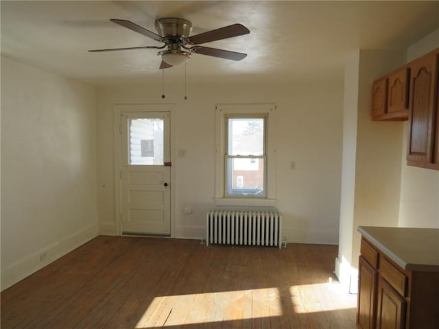 interior space featuring ceiling fan, wood-type flooring, and radiator