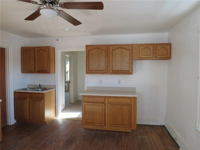 kitchen with dark wood-type flooring, ceiling fan, and sink