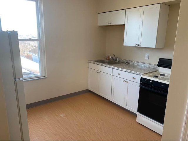 kitchen with white cabinetry, range with electric stovetop, light wood-type flooring, and white fridge