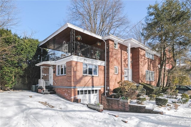 exterior space with a garage, a balcony, and central AC unit