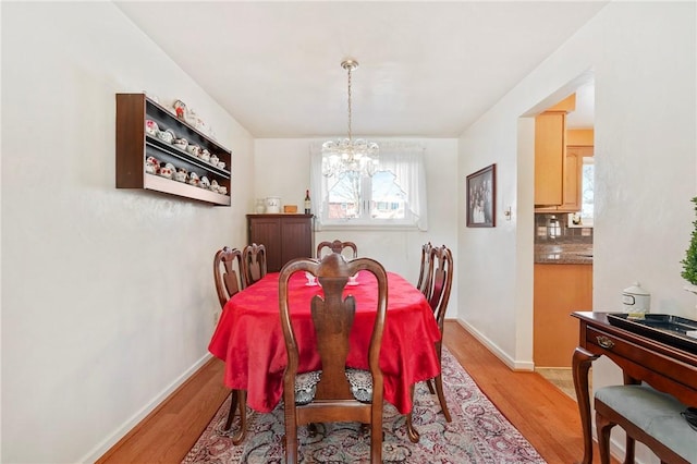 dining room featuring a notable chandelier and light wood-type flooring