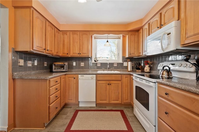 kitchen with sink, tasteful backsplash, light brown cabinets, dark tile patterned floors, and white appliances