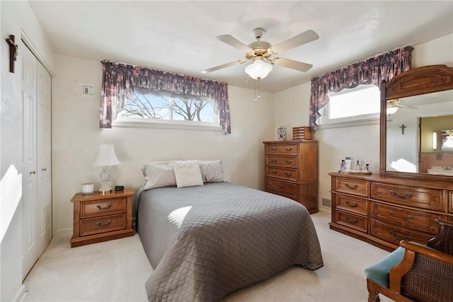 carpeted bedroom with multiple windows, ceiling fan, and a closet