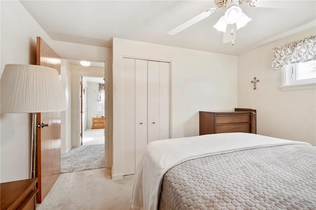 bedroom featuring ceiling fan, light carpet, and a closet