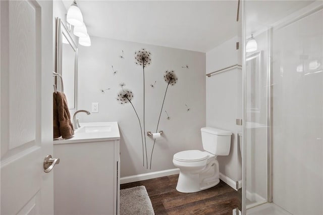 bathroom featuring vanity, hardwood / wood-style flooring, a shower with door, and toilet