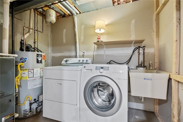 clothes washing area featuring separate washer and dryer, sink, and water heater