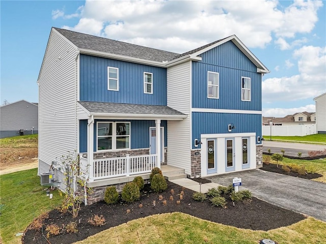 view of front of property featuring a porch, central AC unit, and a front yard