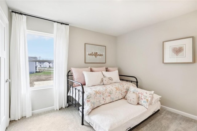 bedroom featuring light colored carpet and multiple windows