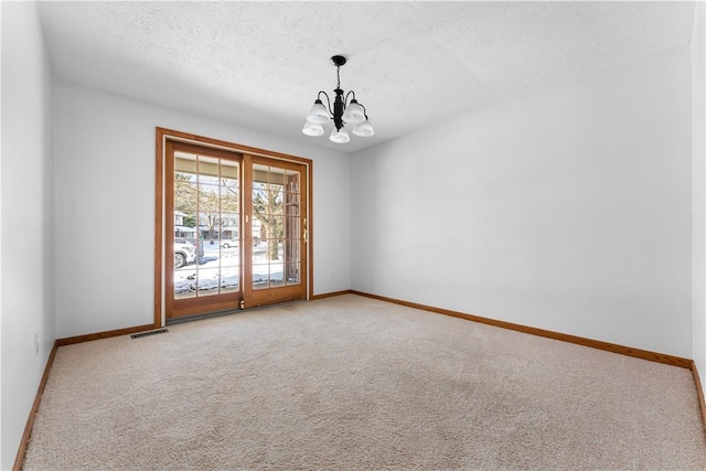 spare room with lofted ceiling, carpet flooring, a notable chandelier, and a textured ceiling