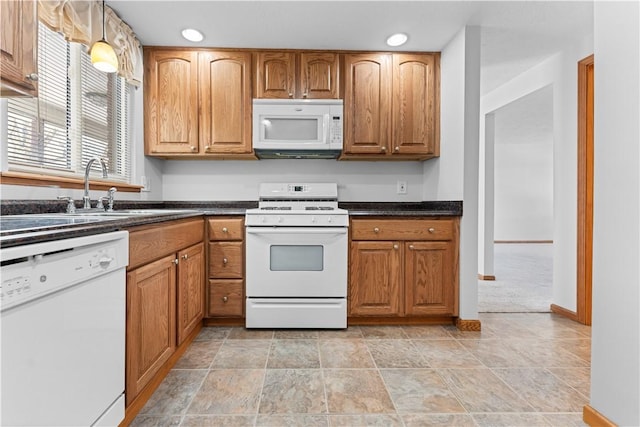 kitchen featuring light colored carpet, white appliances, sink, and hanging light fixtures