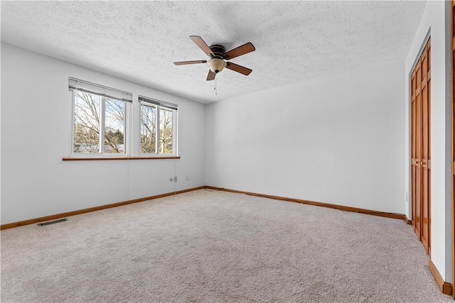 unfurnished bedroom featuring carpet floors, a textured ceiling, and ceiling fan