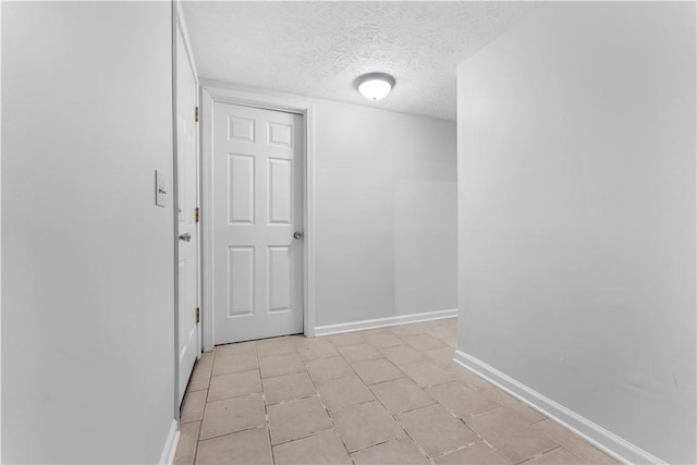 hall featuring a textured ceiling