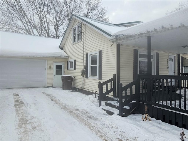 snow covered property with a garage