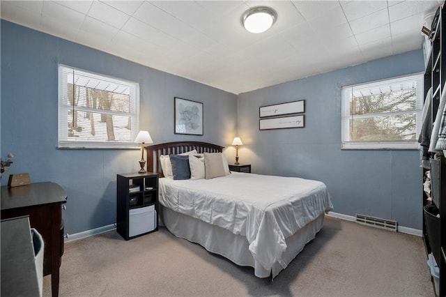 bedroom with light carpet and multiple windows