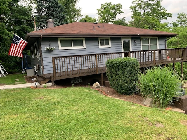 rear view of house featuring a yard and a deck