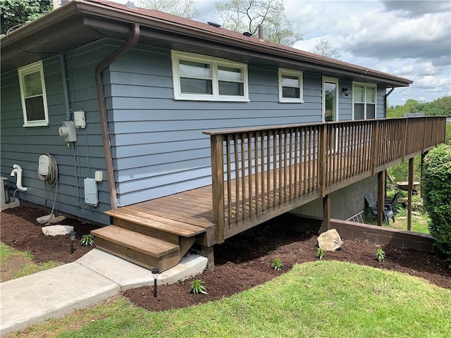 rear view of house with a wooden deck and a lawn